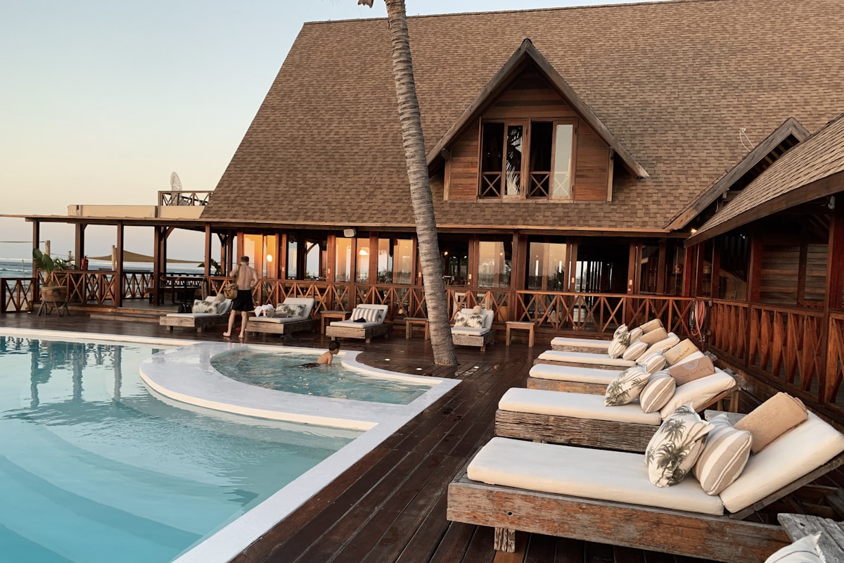 A wooden poolside resort with outdoor lounge space